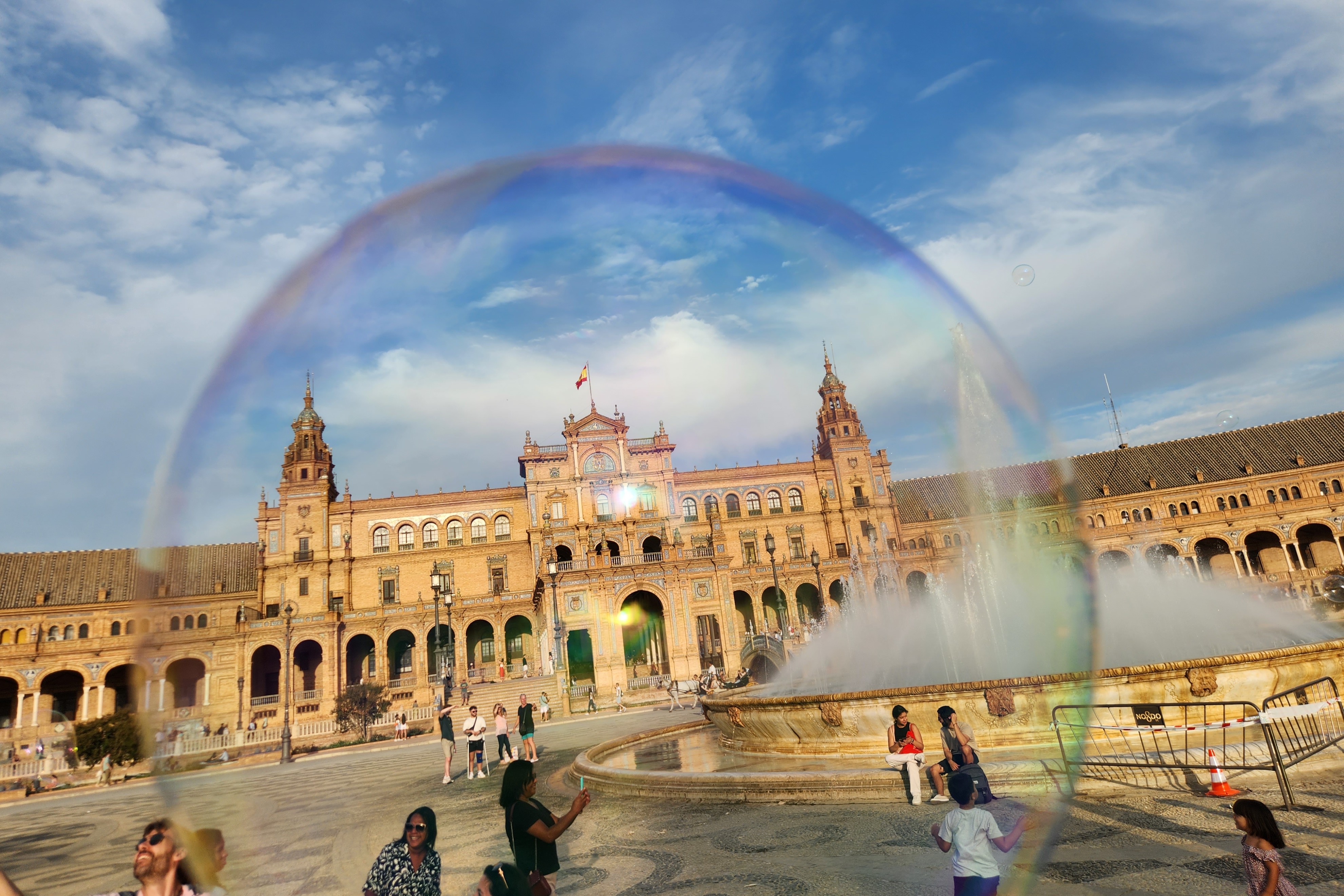 The view of a Spanish plaza and blue sky through a bubble.